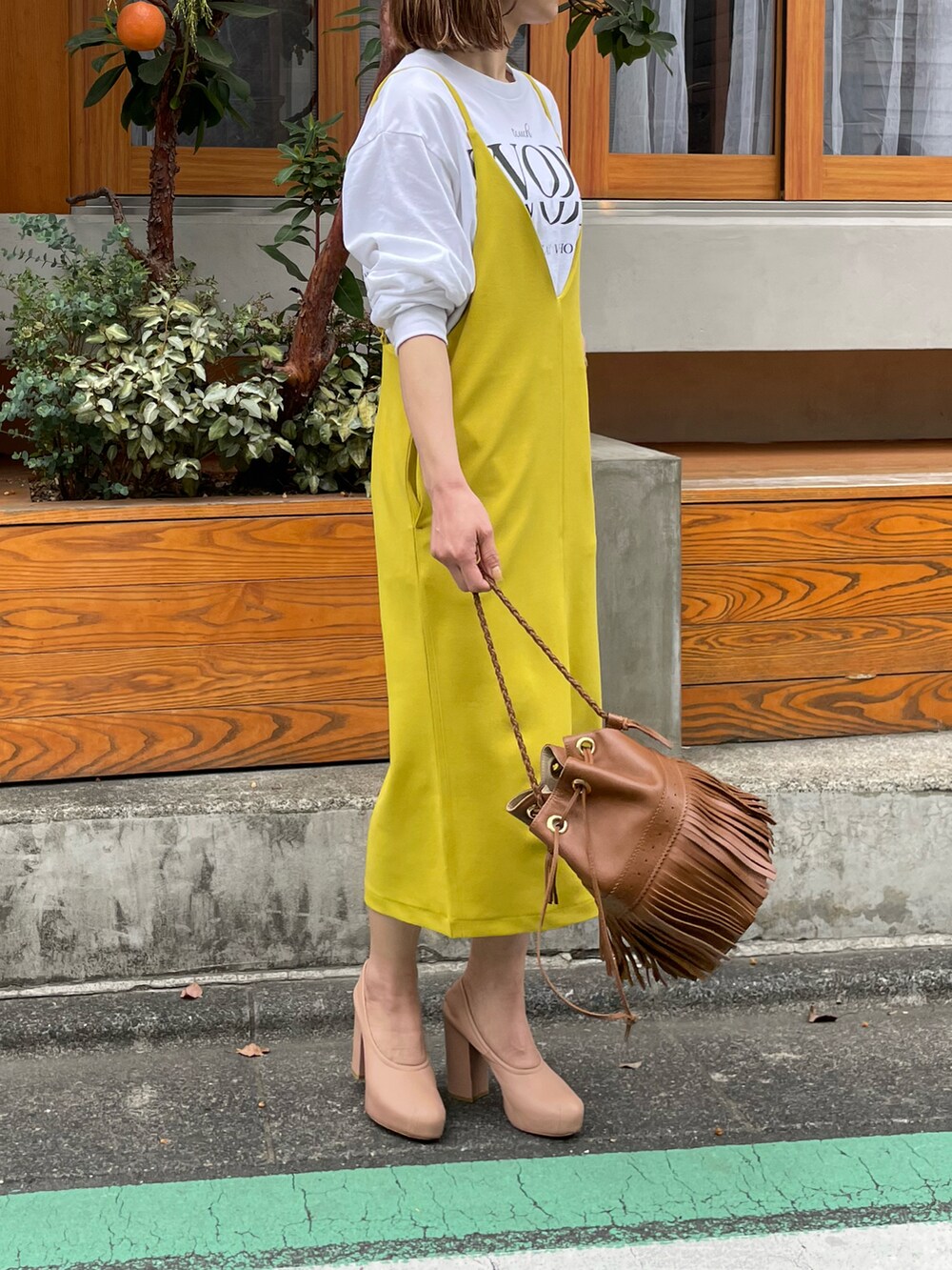 グリーン系のワンピース、ホワイト系のTシャツ/カットソーを着用したレディースの春コーディネートの3枚目の写真
