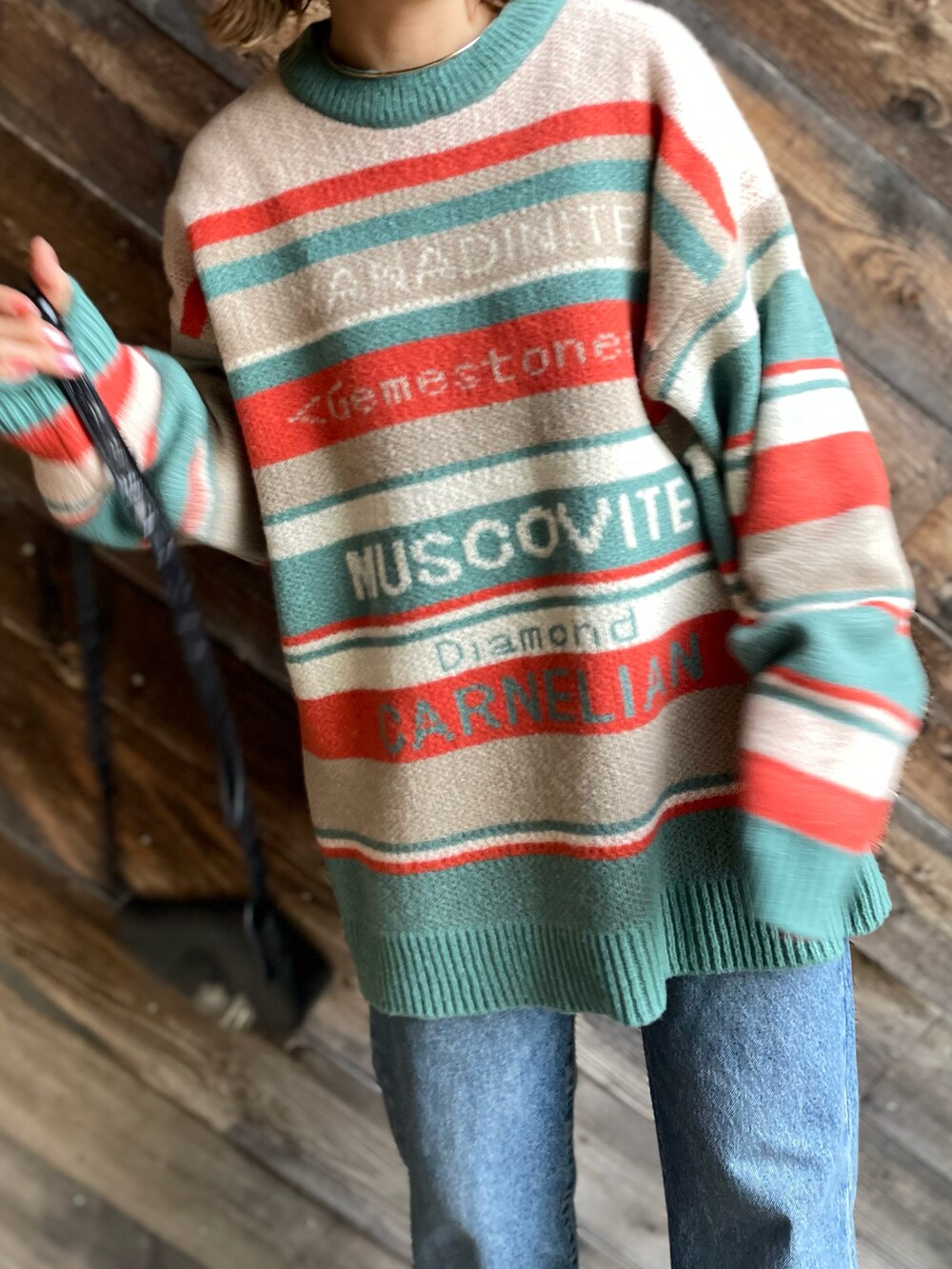 オレンジ系のニット/セーターを着用したレディースの冬コーディネートの3枚目の写真