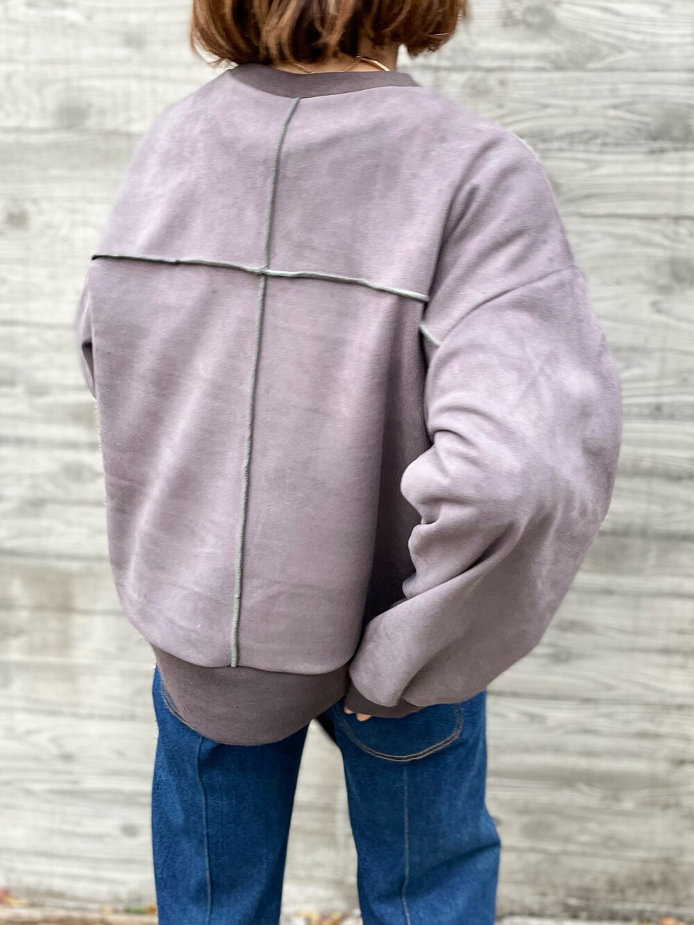 グレー系のスウェット、グリーン系のベストを着用したレディースの秋コーディネートの4枚目の写真