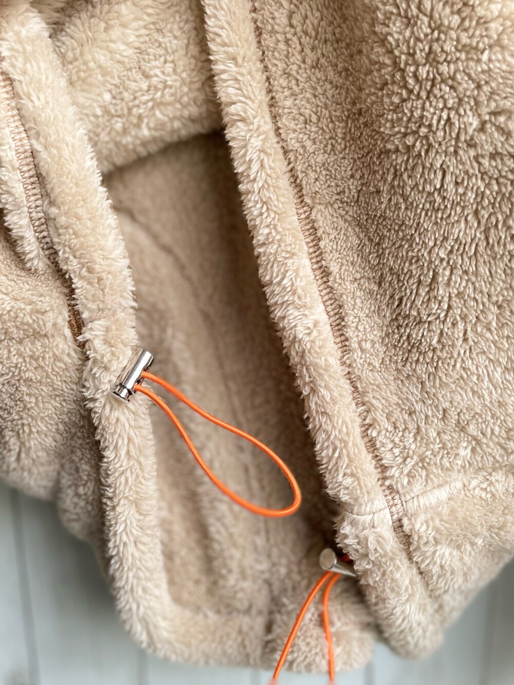 ベージュ系のスウェット、レッド系のスウェットパンツ、ブラック系のブーツを着用したレディースの冬コーディネートの5枚目の写真