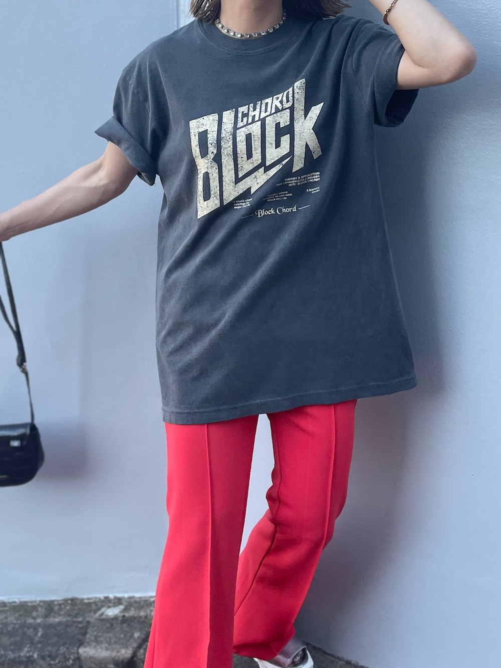 ブラック系のTシャツ/カットソー、オレンジ系のその他パンツを着用したレディースの夏コーディネートの2枚目の写真