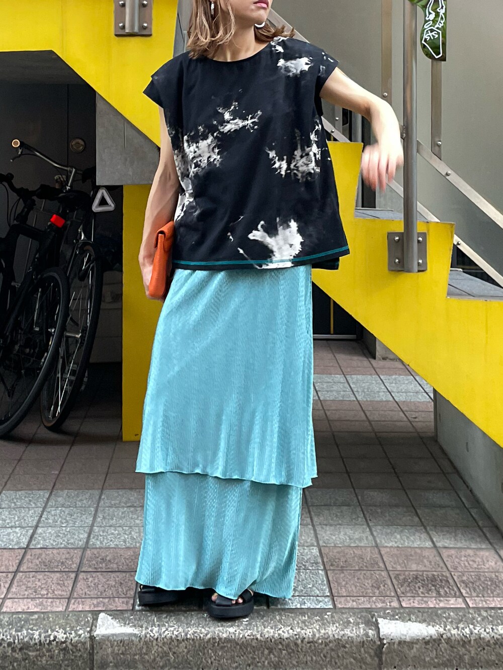 ブラック系のTシャツ/カットソー、ブルー系のスカートを着用したレディースの夏コーディネートの2枚目の写真