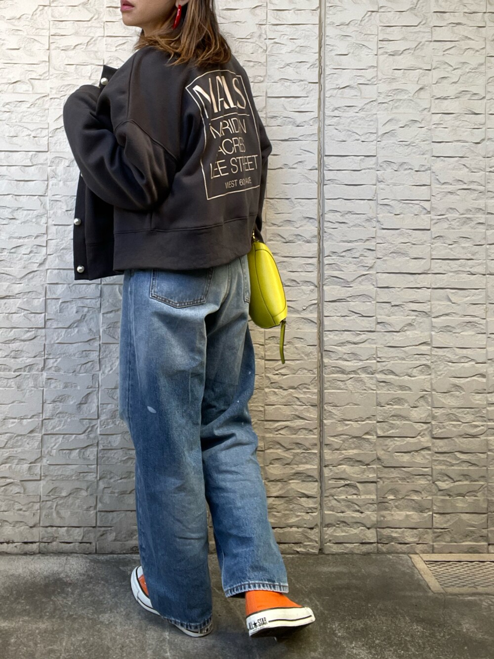 ブラック系のスウェット、オレンジ系のスニーカーを着用したレディースの冬コーディネートの2枚目の写真