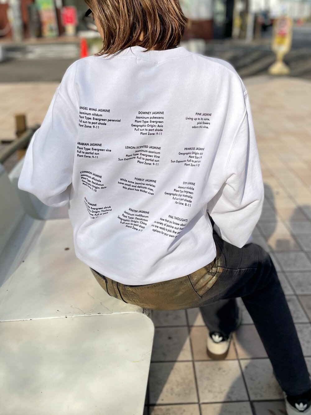 ホワイト系のスウェット、ブラック系のデニムパンツ、ホワイト系のスニーカーを着用したレディースの冬コーディネートの3枚目の写真