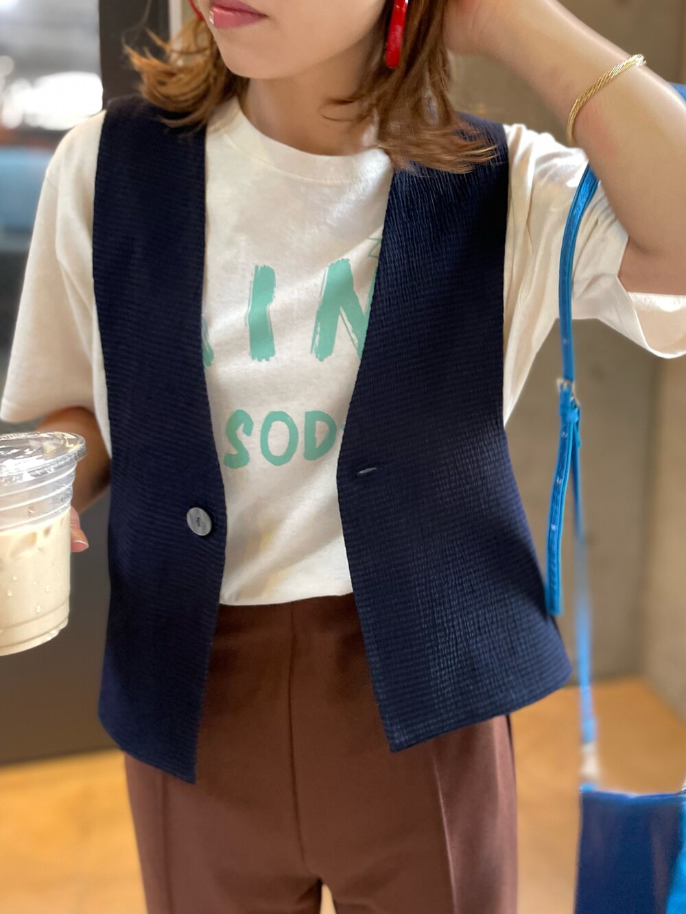 ブルー系のベスト、ベージュ系のTシャツ/カットソー、ブラウン系のその他パンツを着用したレディースの夏コーディネートの2枚目の写真