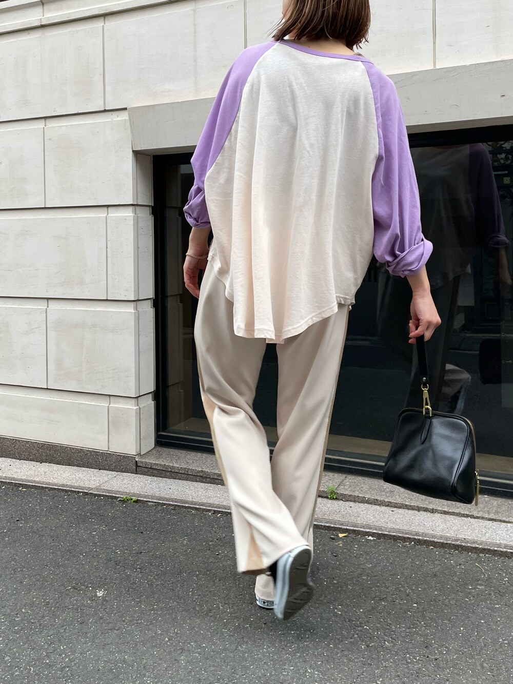 パープル系のTシャツ/カットソー、ブラウン系のタンクトップ、ホワイト系のパンツを着用したレディースの春コーディネートの2枚目の写真