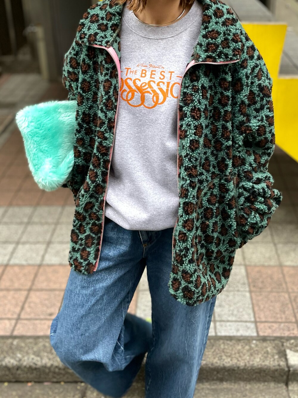 ブルー系のブルゾン、グレー系のスウェット、ブルー系のデニムパンツを着用したレディースの冬コーディネートの3枚目の写真