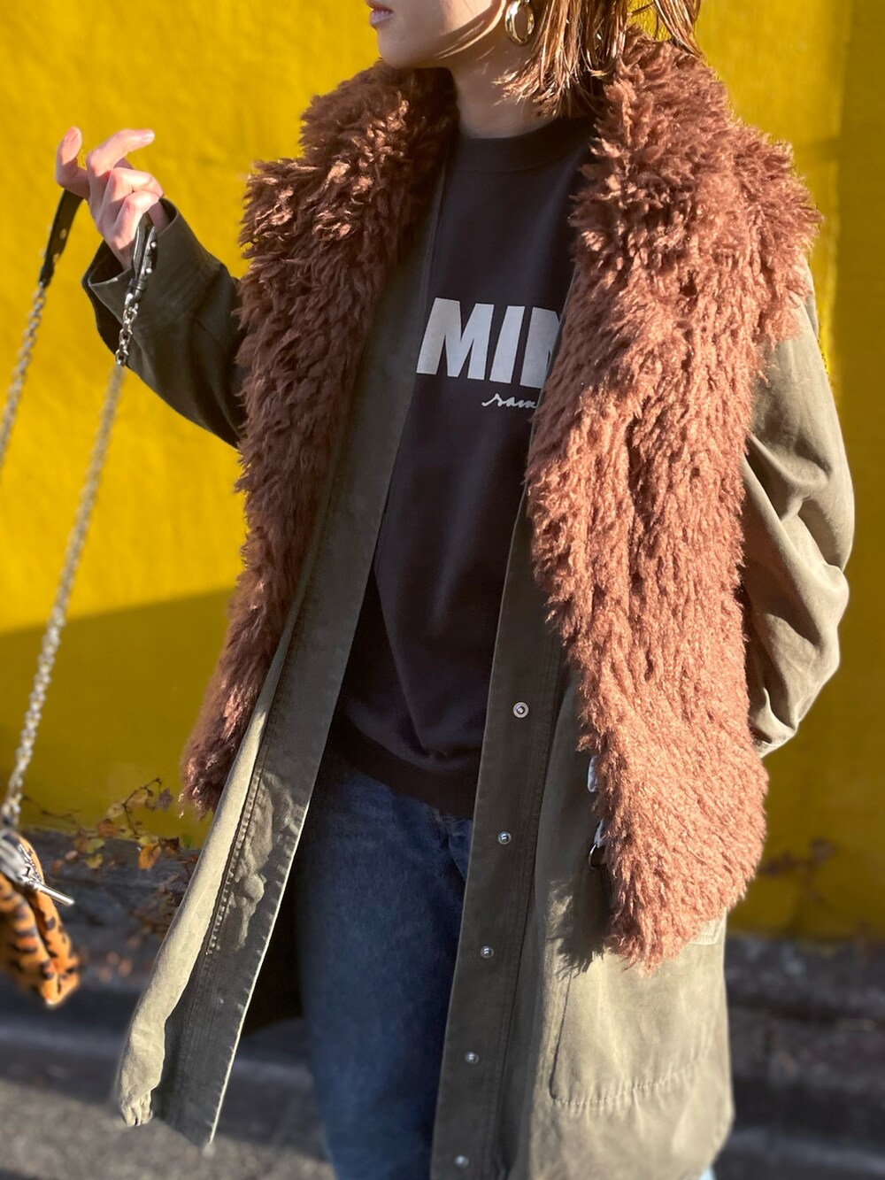 ブラウン系のベスト、ブラック系のスウェットを着用したレディースの冬コーディネートの2枚目の写真