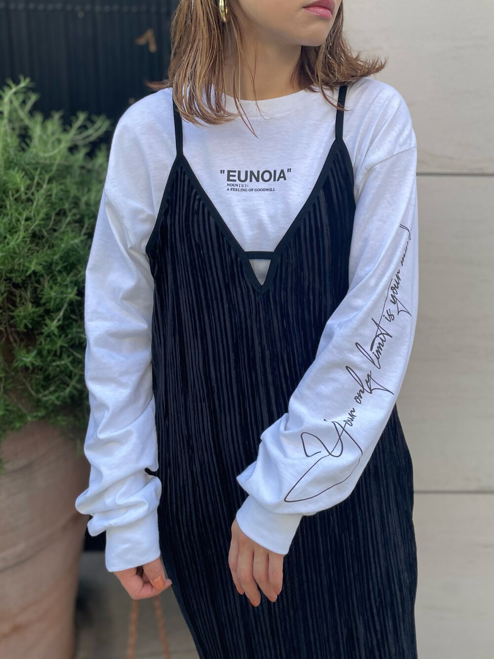 ブラック系のワンピース、ホワイト系のTシャツ/カットソー、ブラック系のスニーカーを着用したレディースの秋コーディネートの2枚目の写真