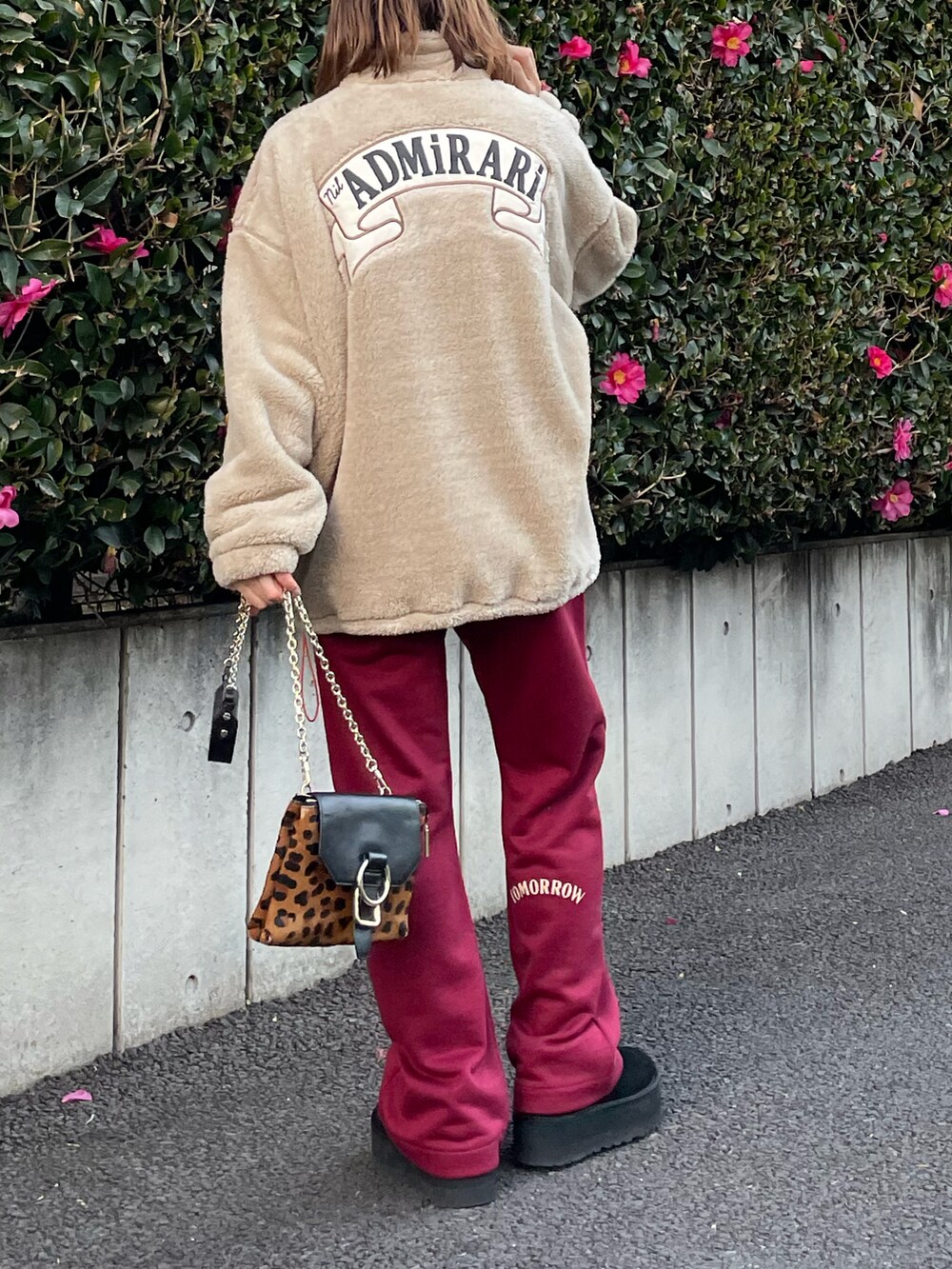 ベージュ系のスウェット、レッド系のスウェットパンツ、ブラック系のブーツを着用したレディースの冬コーディネートの2枚目の写真