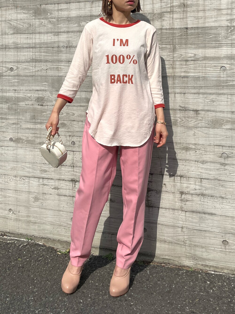 オレンジ系のTシャツ/カットソー、ピンク系のパンツを着用したレディースの春コーディネートの3枚目の写真