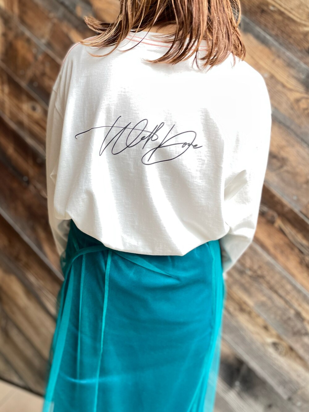 ホワイト系のTシャツ/カットソー、ブルー系のワンピース、ブラック系のスニーカーを着用したレディースの秋コーディネートの5枚目の写真