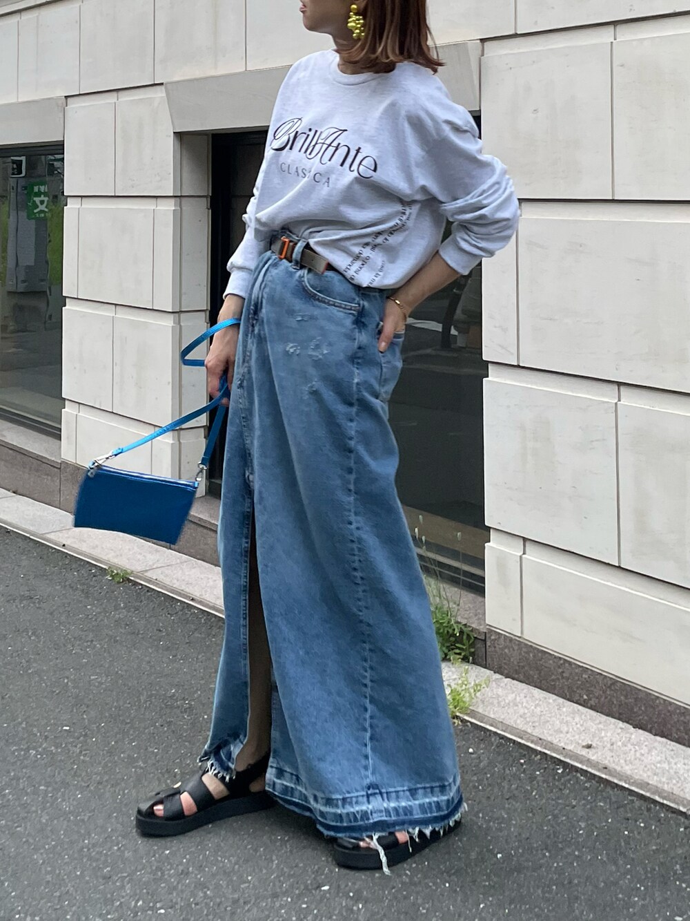 ベージュ系のTシャツ/カットソー、ブルー系のデニムスカートを着用したレディースの春コーディネートの2枚目の写真