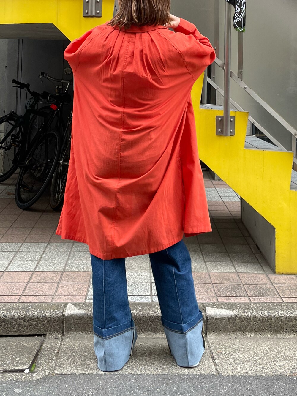 オレンジ系のシャツ/ブラウス、ホワイト系のタンクトップ、ブラック系のスニーカーを着用したレディースの春コーディネートの4枚目の写真