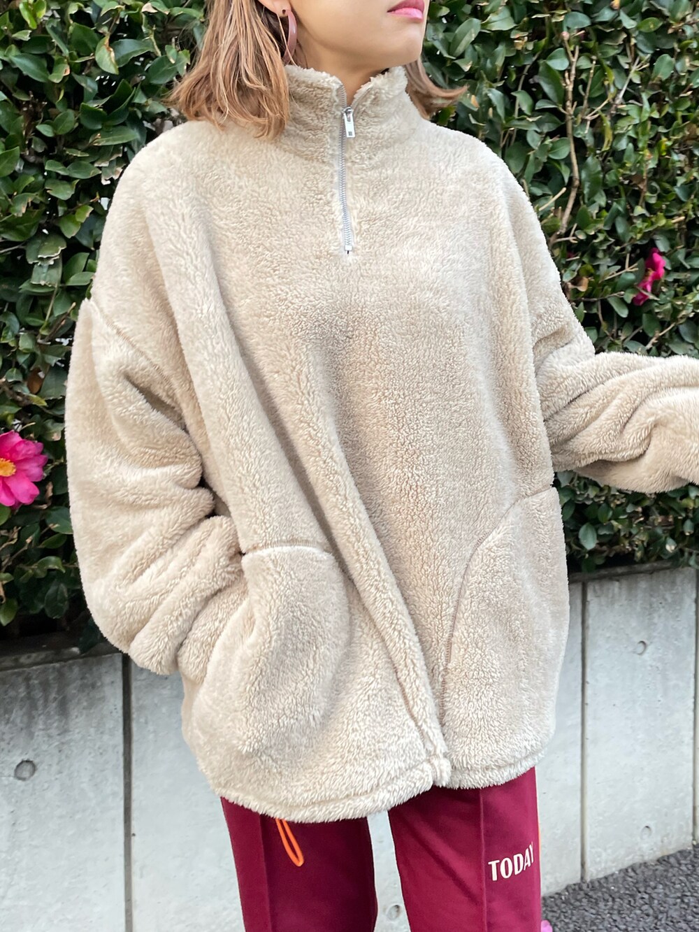 ベージュ系のスウェット、レッド系のスウェットパンツ、ブラック系のブーツを着用したレディースの冬コーディネートの3枚目の写真
