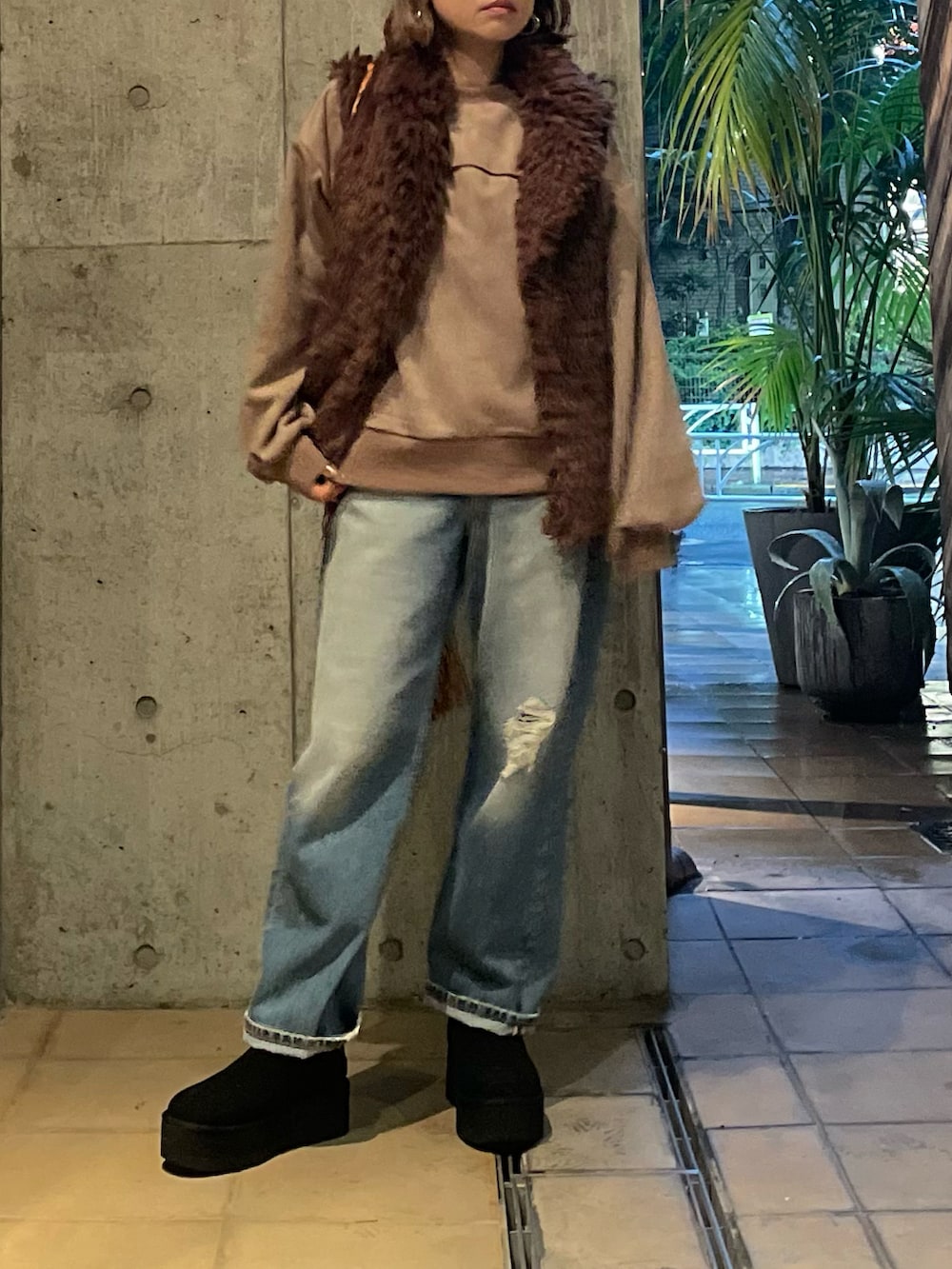 ベージュ系のスウェット、ブラウン系のベスト、ブラック系のブーツを着用したレディースの秋コーディネートの3枚目の写真