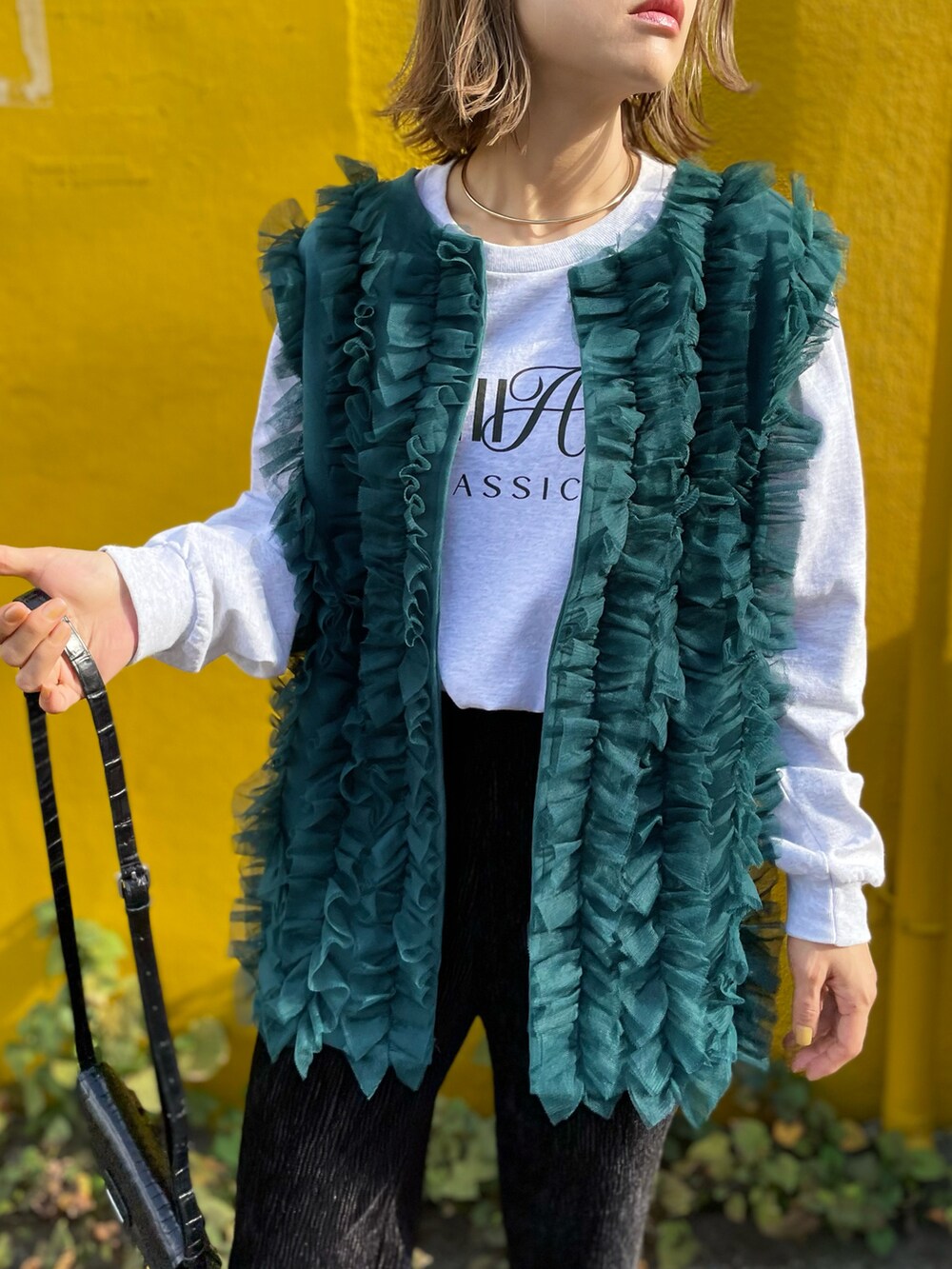 ブルー系のベスト、ベージュ系のTシャツ/カットソー、ブラック系のその他パンツを着用したレディースの秋コーディネートの2枚目の写真