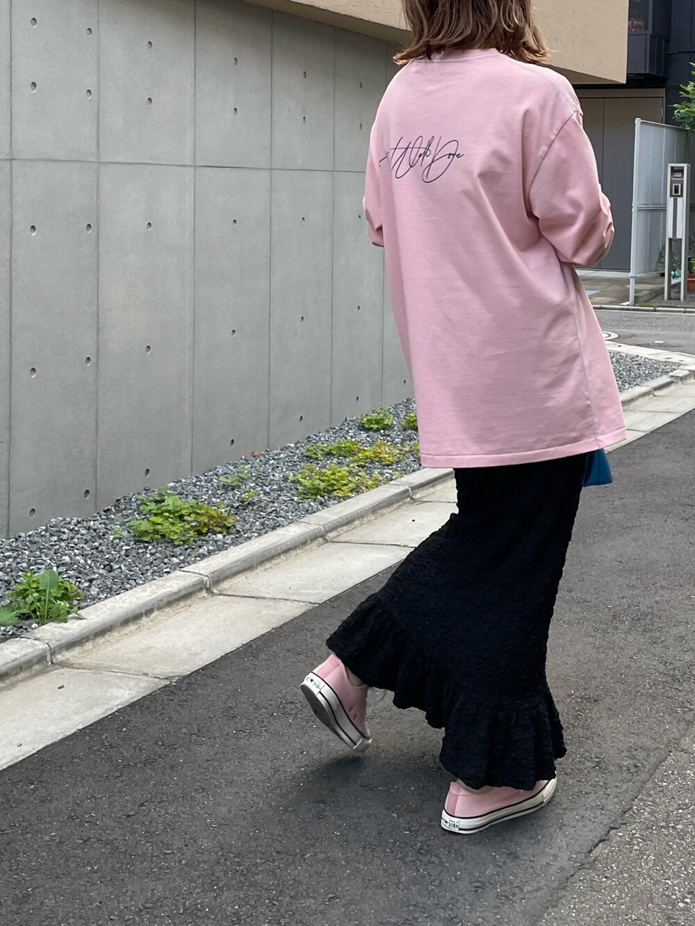 ピンク系のTシャツ/カットソー、ブラック系のスカート、ピンク系のスニーカーを着用したレディースの夏コーディネートの2枚目の写真