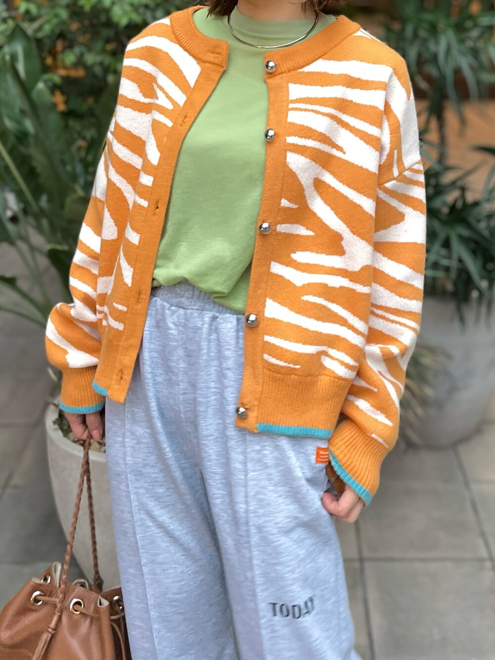 イエロー系のカーディガン/ボレロ、グレー系のスウェットパンツを着用したレディースの冬コーディネートの3枚目の写真