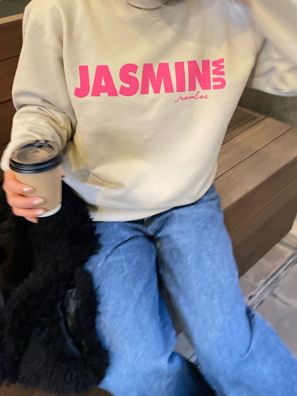 ベージュ系のスウェット、ブルー系のデニムパンツを着用したレディースの冬コーディネートの2枚目の写真