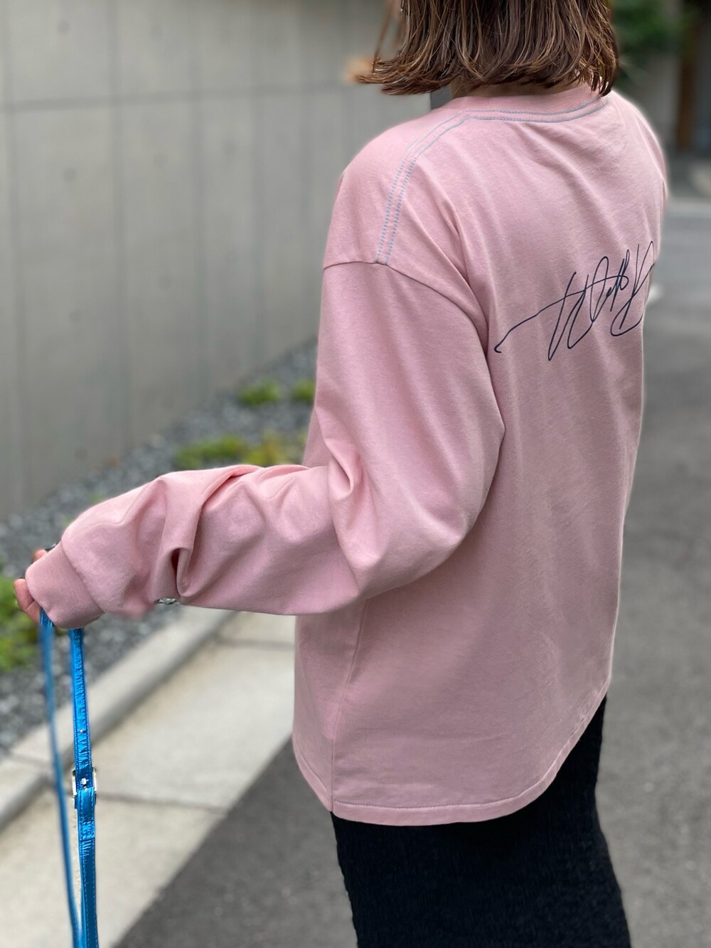 ピンク系のTシャツ/カットソー、ブラック系のスカート、ピンク系のスニーカーを着用したレディースの夏コーディネートの4枚目の写真