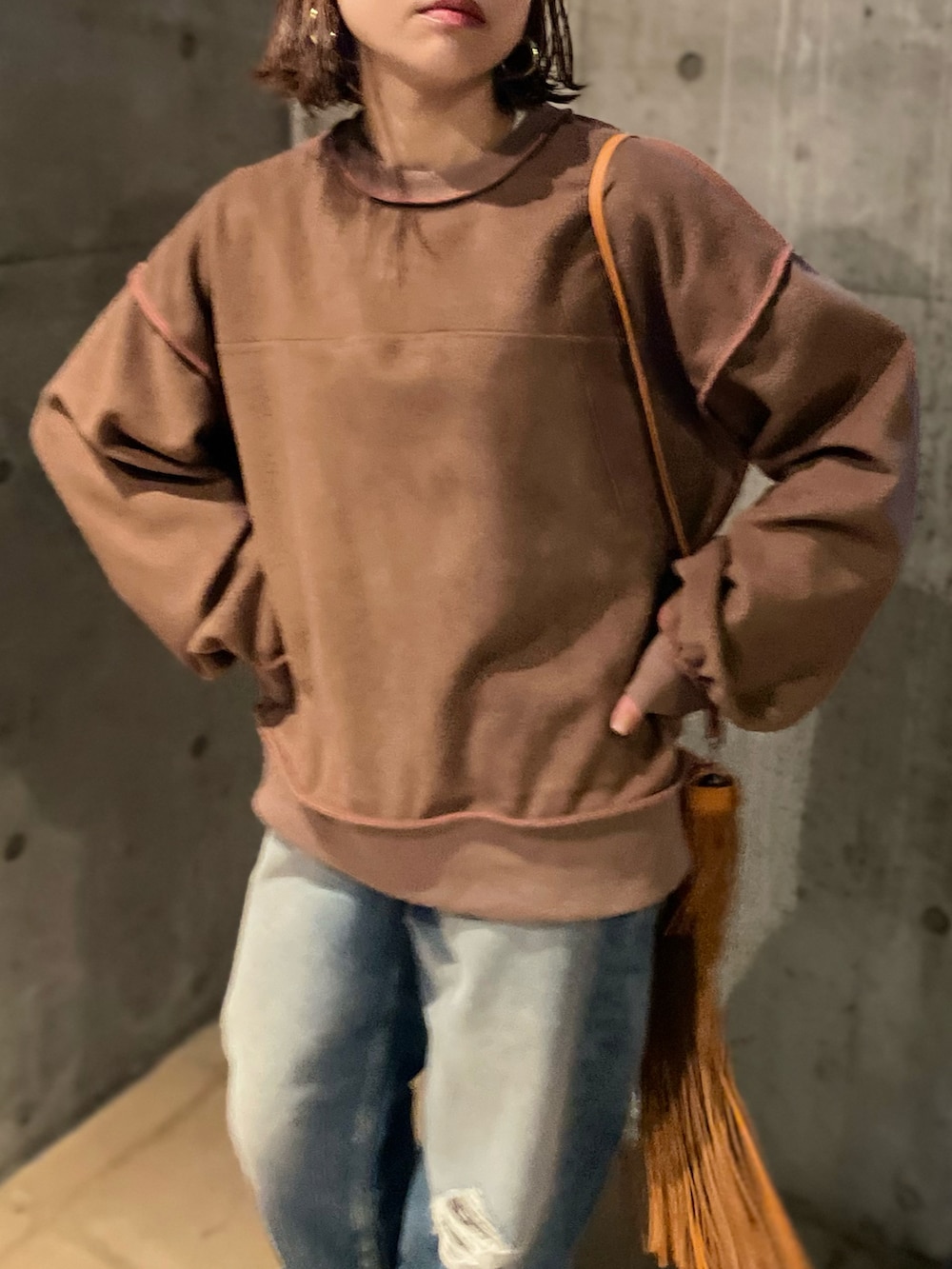 ベージュ系のスウェット、ブラウン系のベスト、ブラック系のブーツを着用したレディースの秋コーディネートの5枚目の写真