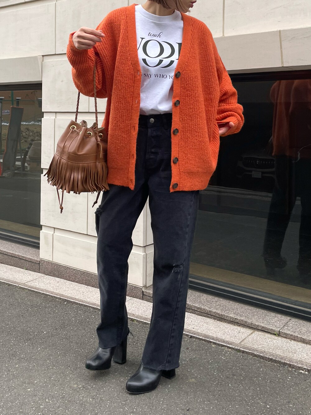 オレンジ系のカーディガン/ボレロ、ホワイト系のTシャツ/カットソーを着用したレディースの冬コーディネートの5枚目の写真