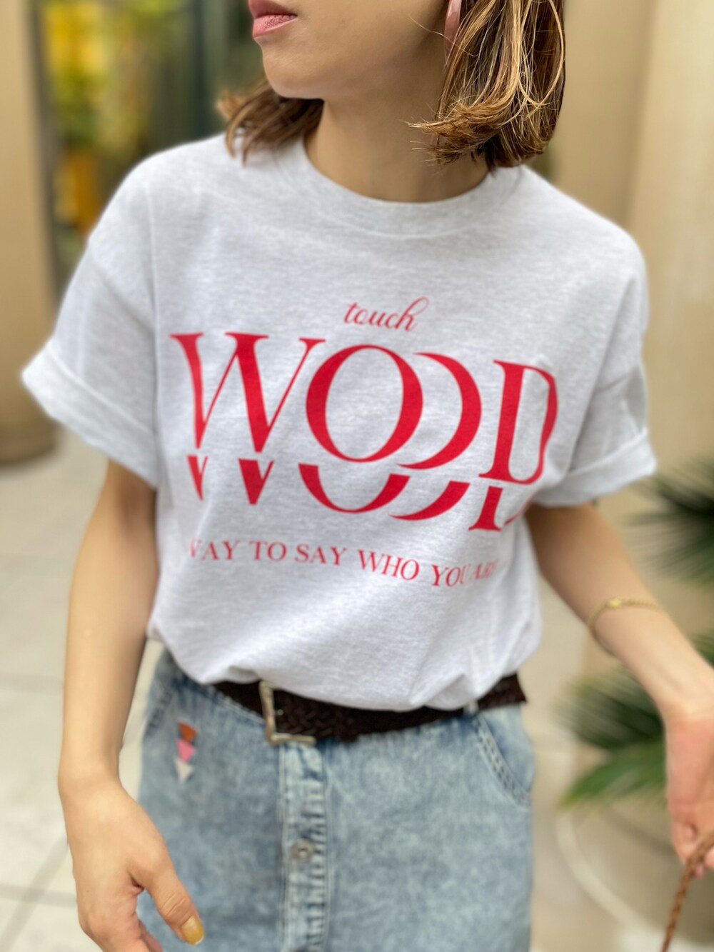 ベージュ系のTシャツ/カットソー、ブルー系のデニムスカートを着用したレディースの夏コーディネートの2枚目の写真