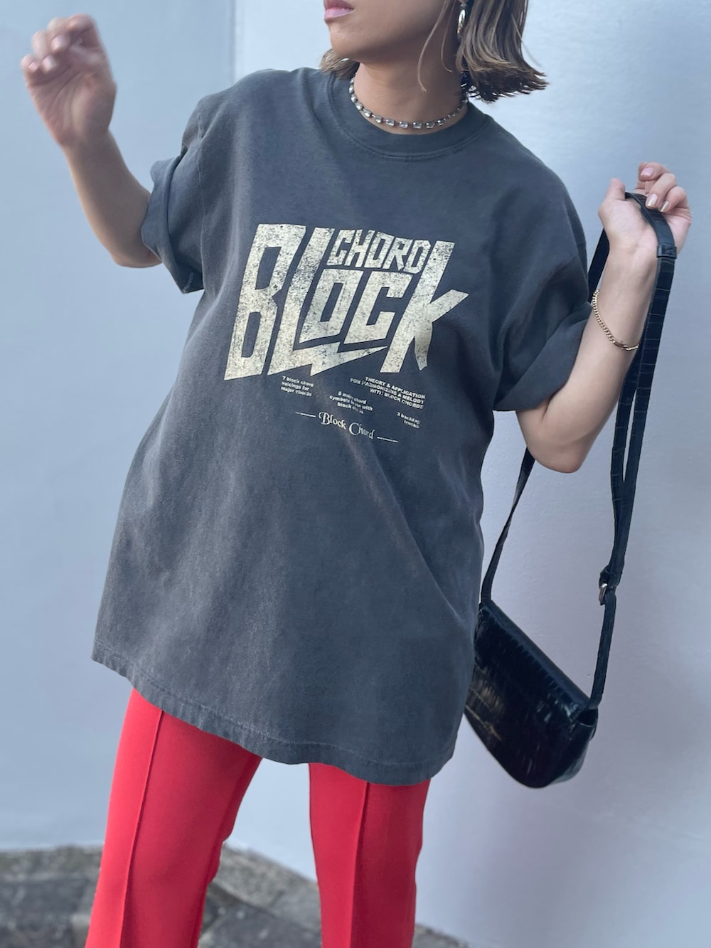 ブラック系のTシャツ/カットソー、オレンジ系のその他パンツを着用したレディースの夏コーディネートの4枚目の写真