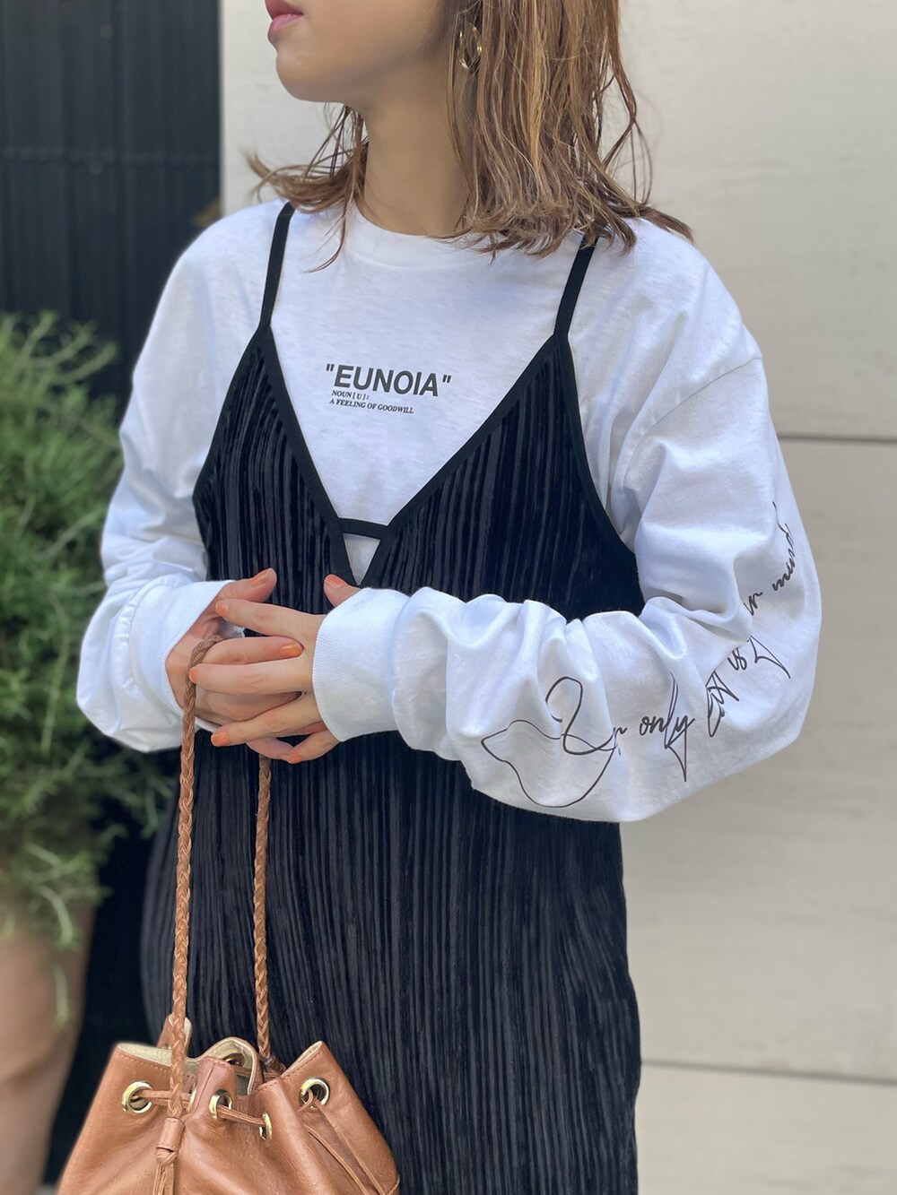 ブラック系のワンピース、ホワイト系のTシャツ/カットソー、ブラック系のスニーカーを着用したレディースの秋コーディネートの4枚目の写真