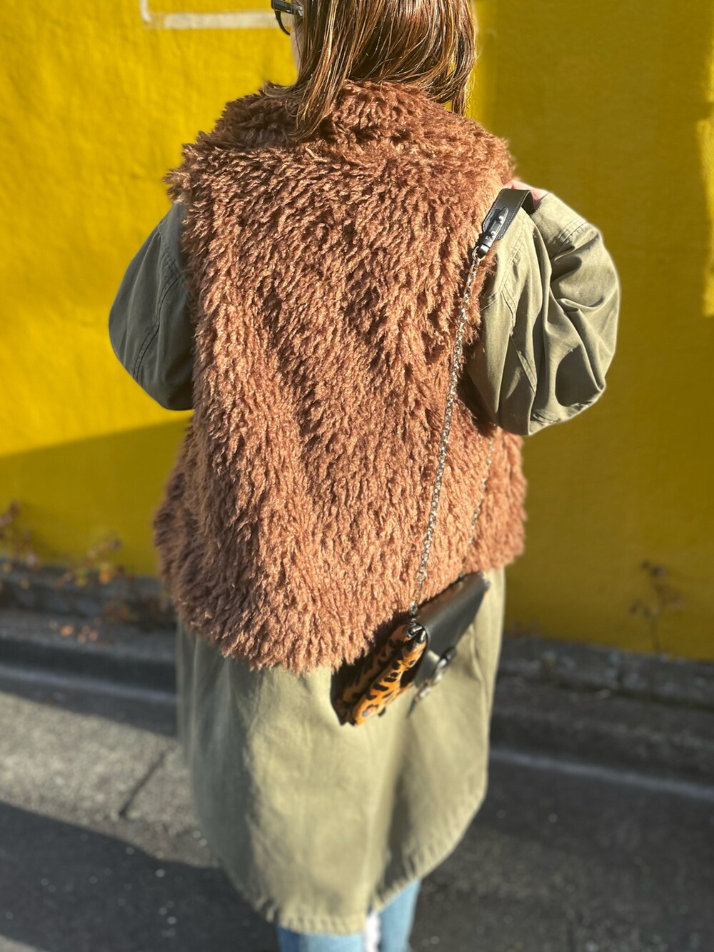 ブラウン系のベスト、ブラック系のスウェットを着用したレディースの冬コーディネートの3枚目の写真