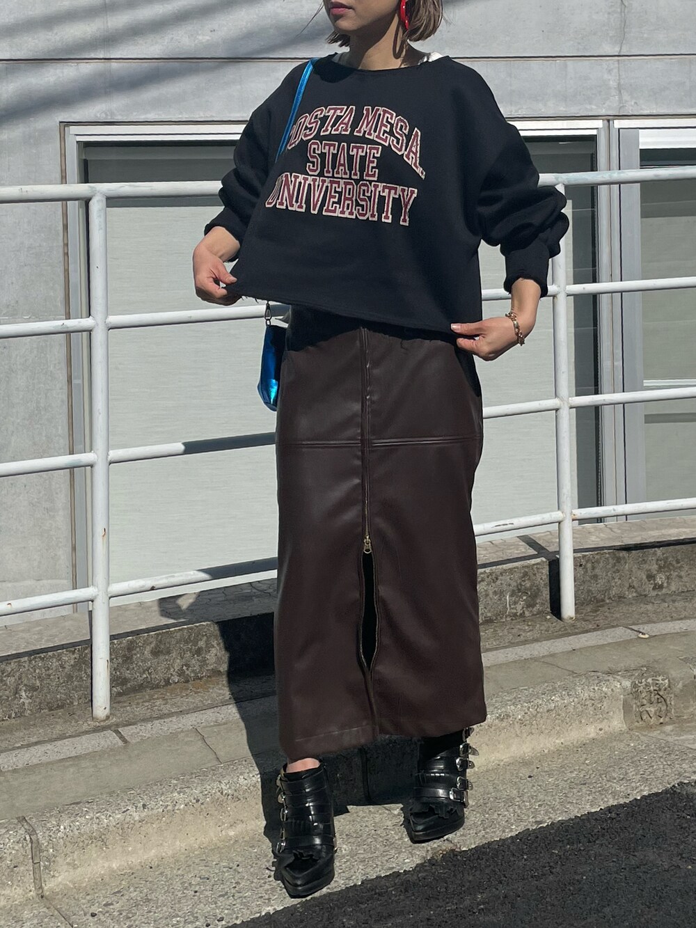 ブラック系のスウェット、ブラウン系のスカート、ホワイト系のタンクトップを着用したレディースの冬コーディネートの5枚目の写真