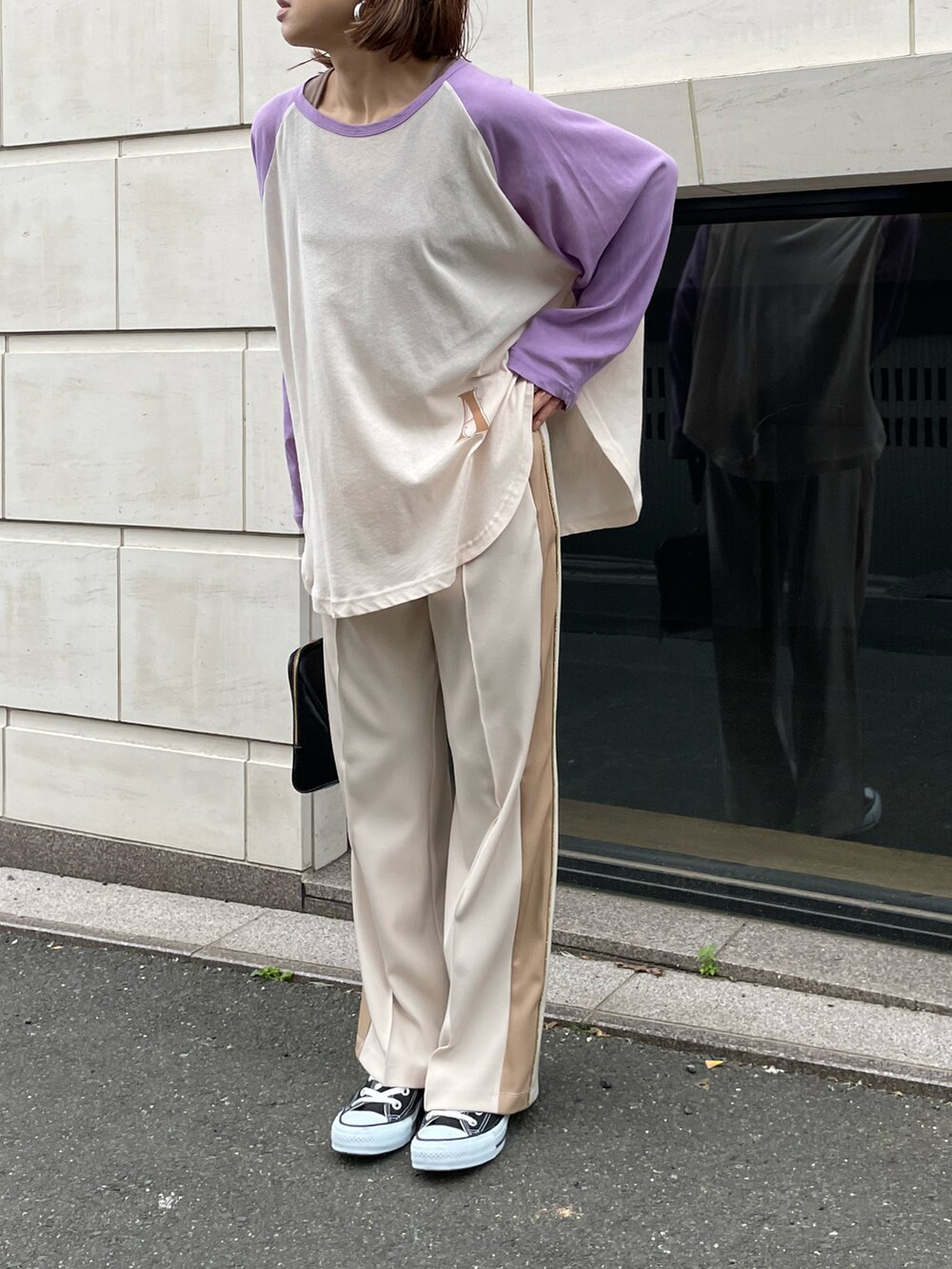 パープル系のTシャツ/カットソー、ブラウン系のタンクトップ、ホワイト系のパンツを着用したレディースの春コーディネートの4枚目の写真