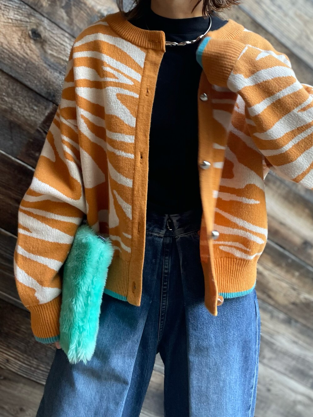 イエロー系のカーディガン/ボレロを着用したレディースの冬コーディネートの2枚目の写真