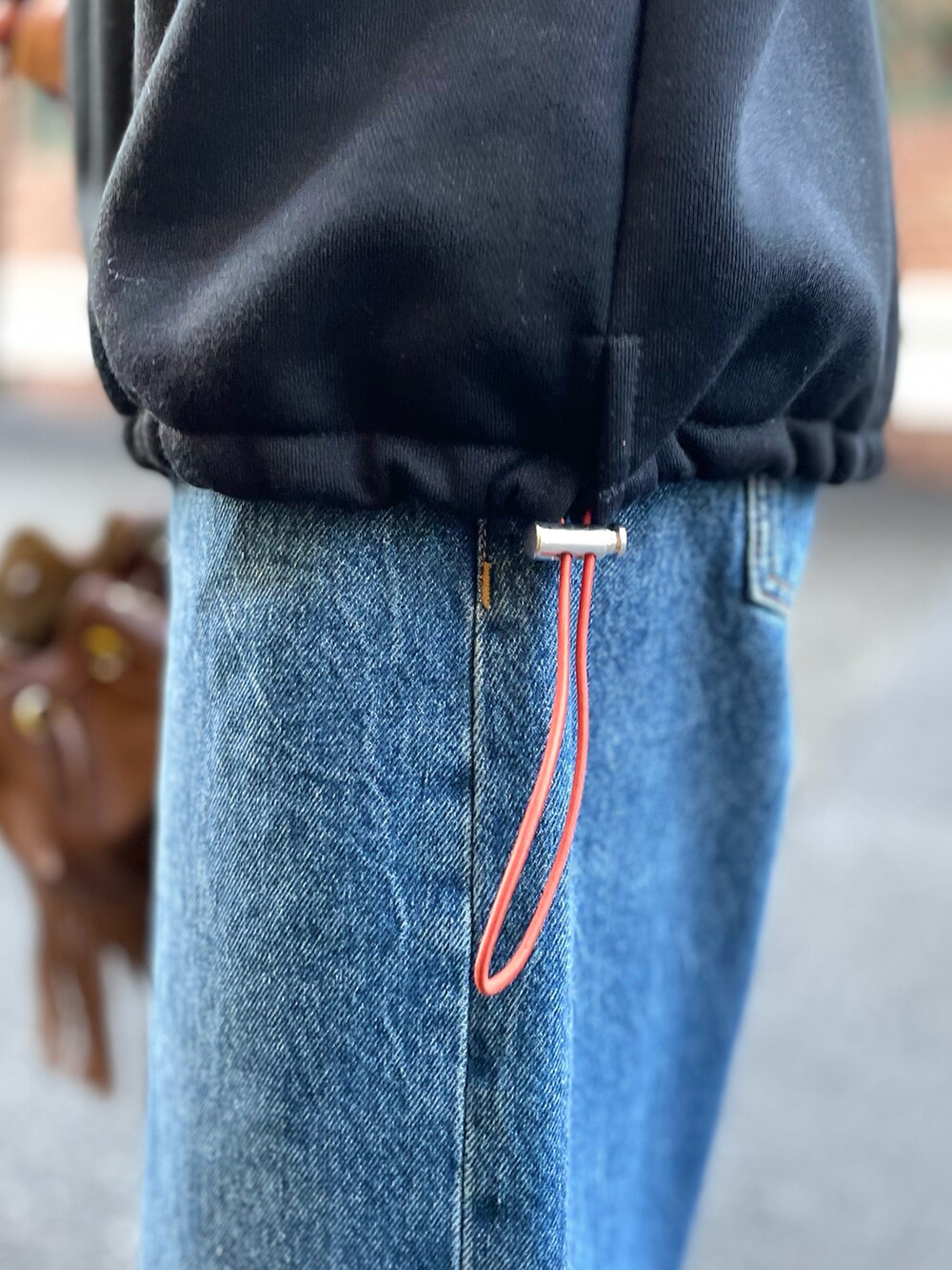 ブラック系のスウェット、ブルー系のデニムパンツを着用したレディースの秋コーディネートの4枚目の写真