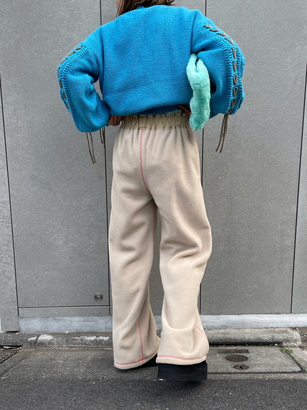 ブルー系のニット/セーター、ベージュ系のその他パンツ、ブラック系のブーツを着用したレディースの冬コーディネートの5枚目の写真