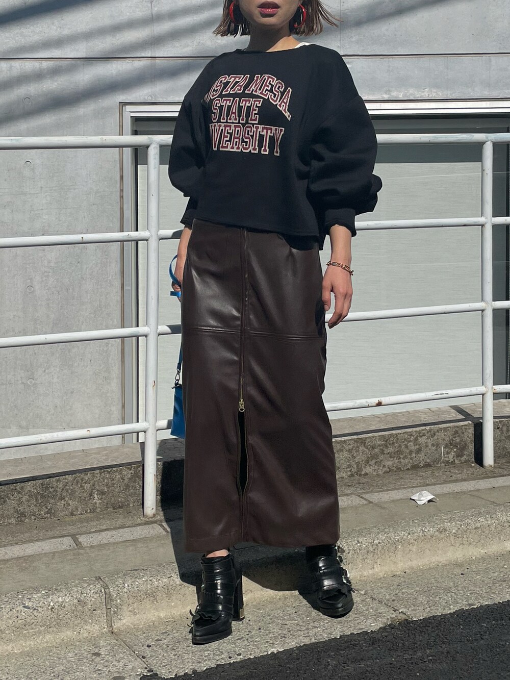 ブラック系のスウェット、ブラウン系のスカート、ホワイト系のタンクトップを着用したレディースの冬コーディネートの3枚目の写真