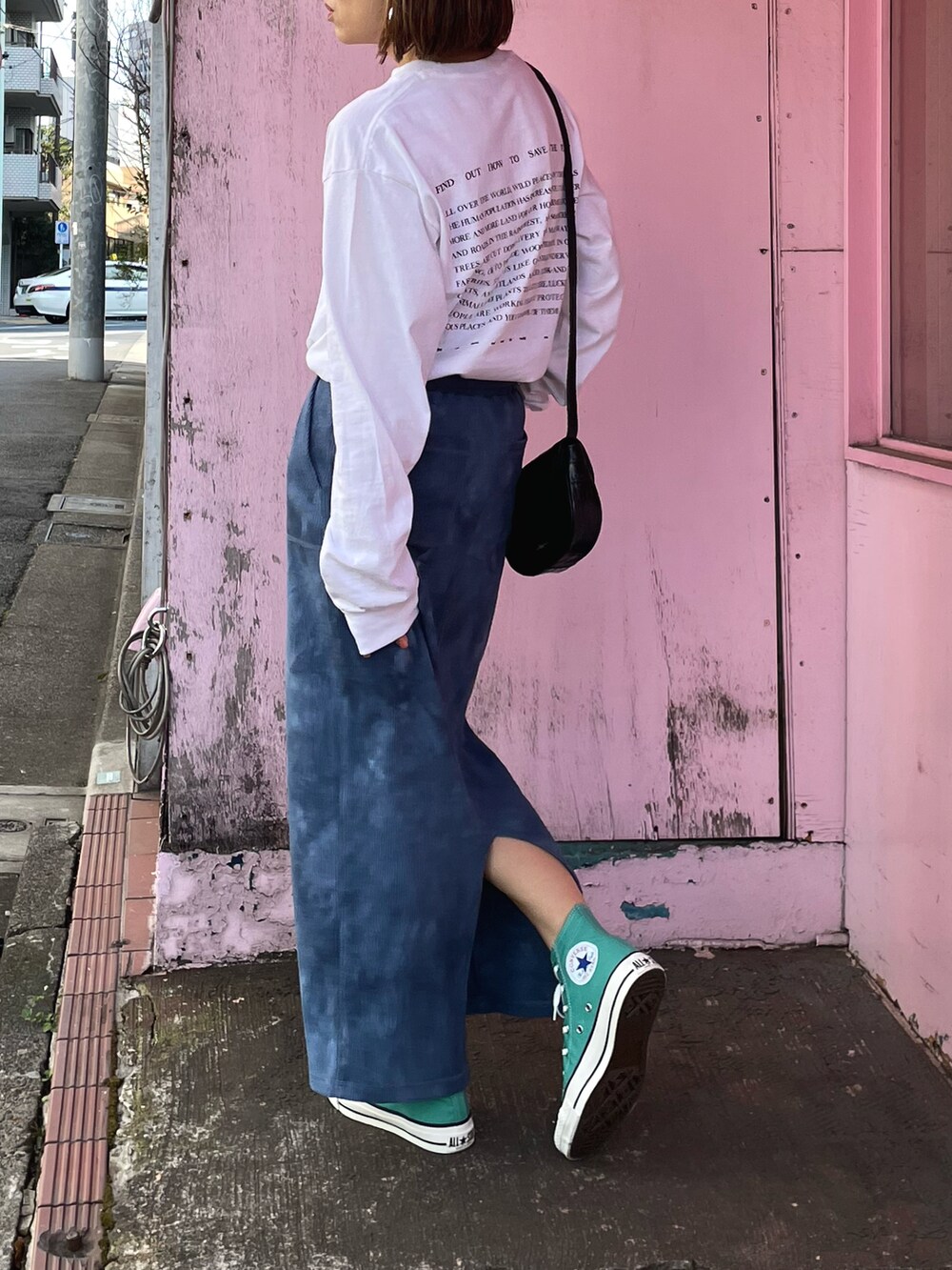 ブルー系のスカート、グリーン系のスニーカー、ホワイト系のTシャツ/カットソーを着用したレディースの春コーディネートの2枚目の写真