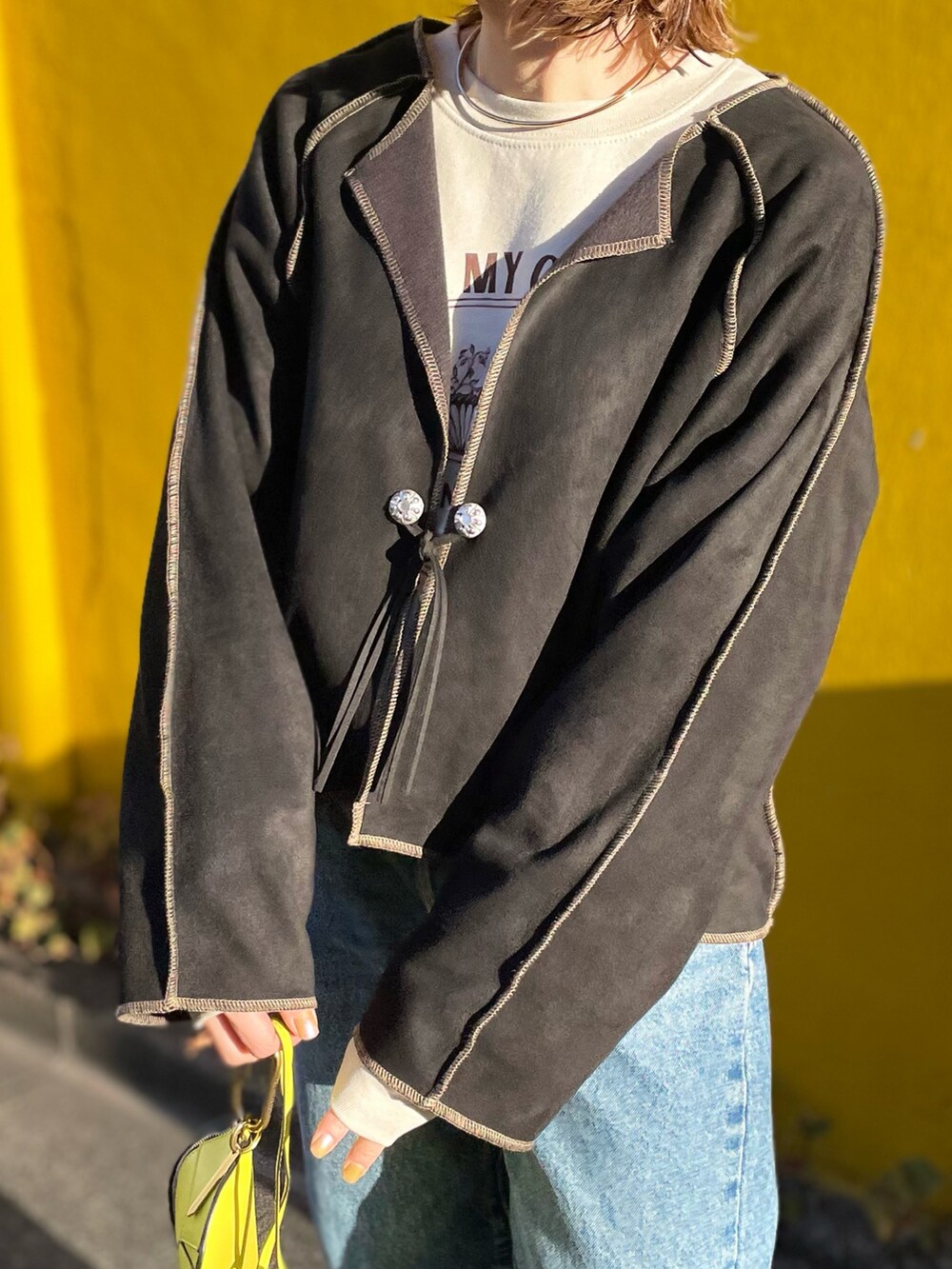 ブラック系のノーカラージャケット、ベージュ系のスウェット、ブラック系のブーツを着用したレディースの冬コーディネートの3枚目の写真