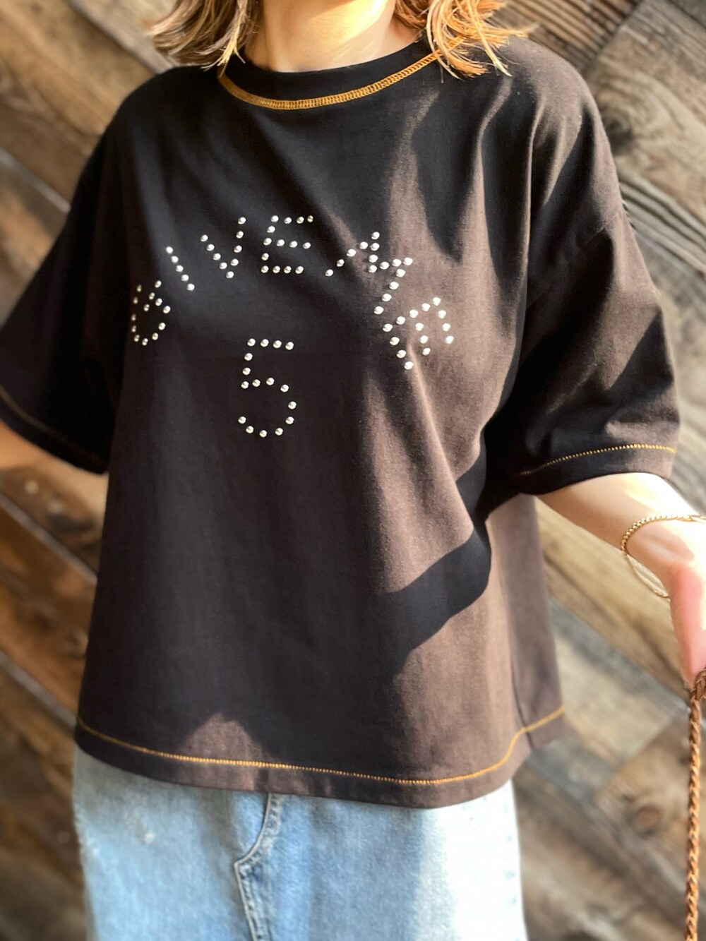 ブラック系のTシャツ/カットソー、ブルー系のデニムスカートを着用したレディースの夏コーディネートの3枚目の写真
