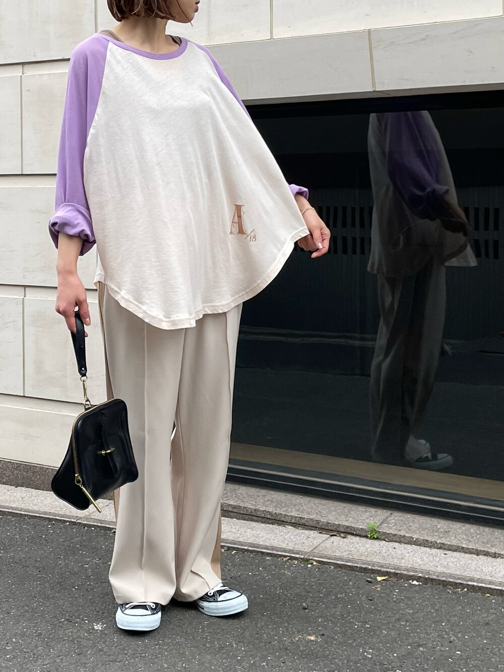 パープル系のTシャツ/カットソー、ブラウン系のタンクトップ、ホワイト系のパンツを着用したレディースの春コーディネートの3枚目の写真