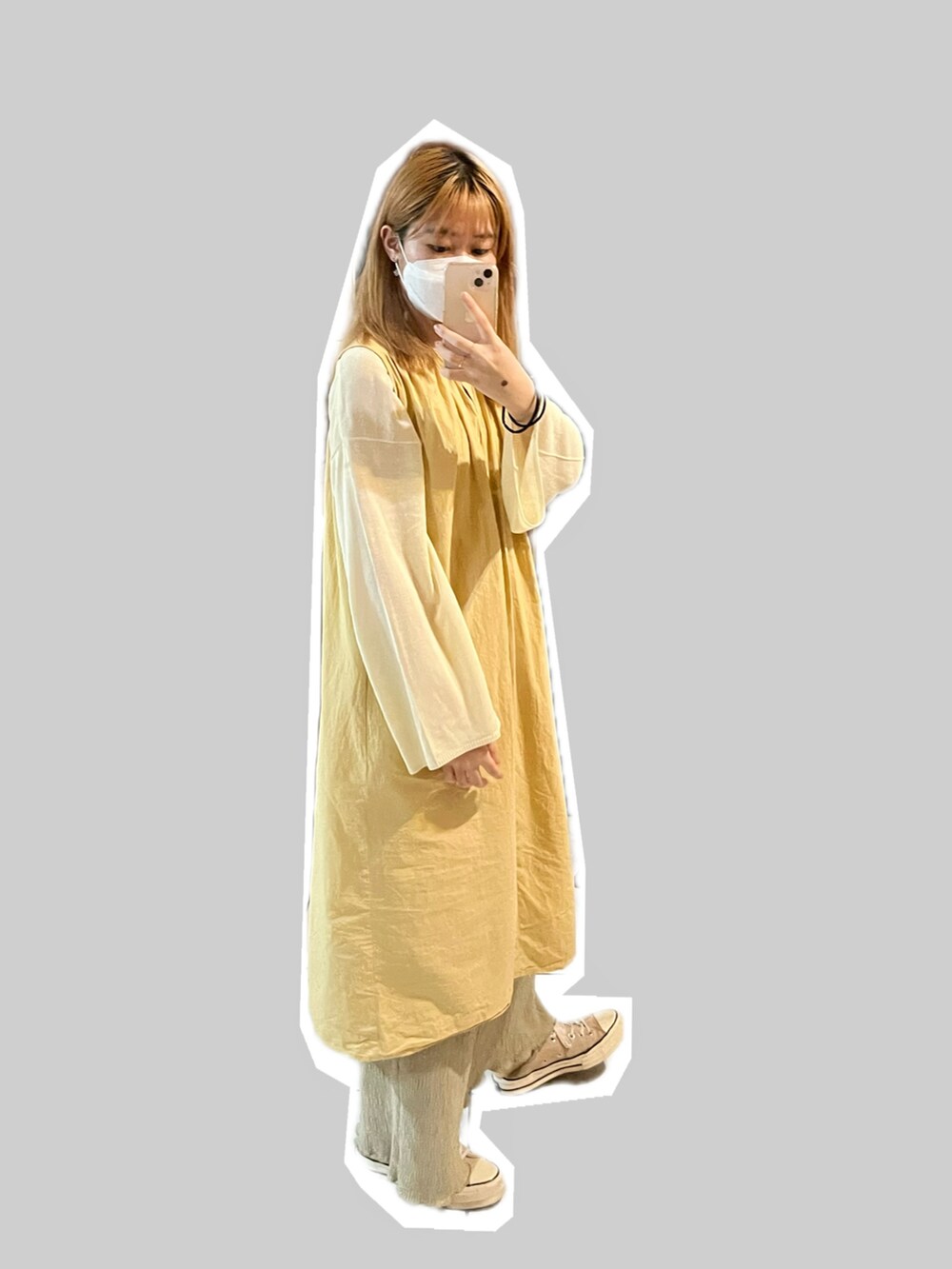 イエロー系のシャツワンピース、ベージュ系のニット/セーター、グリーン系のチノパンツを着用したレディースの秋コーディネートの3枚目の写真