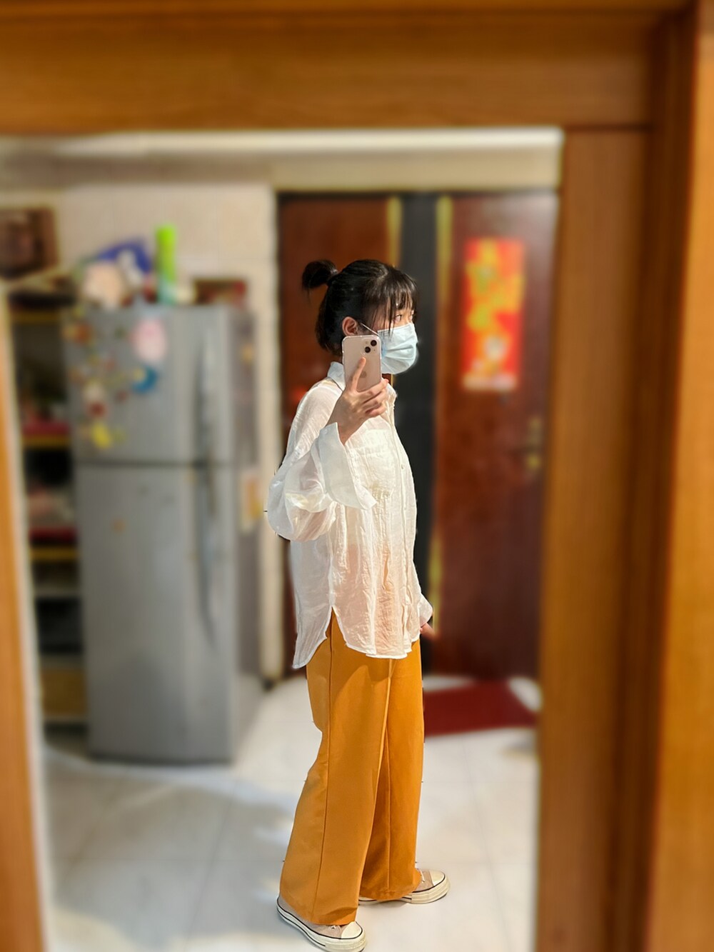 オレンジ系のスラックス、ホワイト系のシャツ/ブラウス、ホワイト系のチューブトップを着用したレディースの秋コーディネートの4枚目の写真