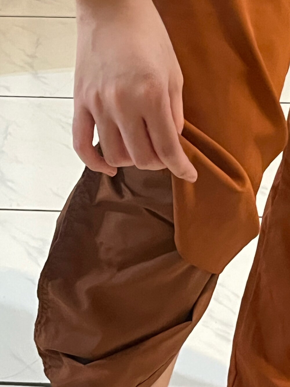 ブラウン系のチノパンツ、ベージュ系のシューズ、ベージュ系のTシャツ/カットソーを着用したレディースの秋コーディネートの5枚目の写真