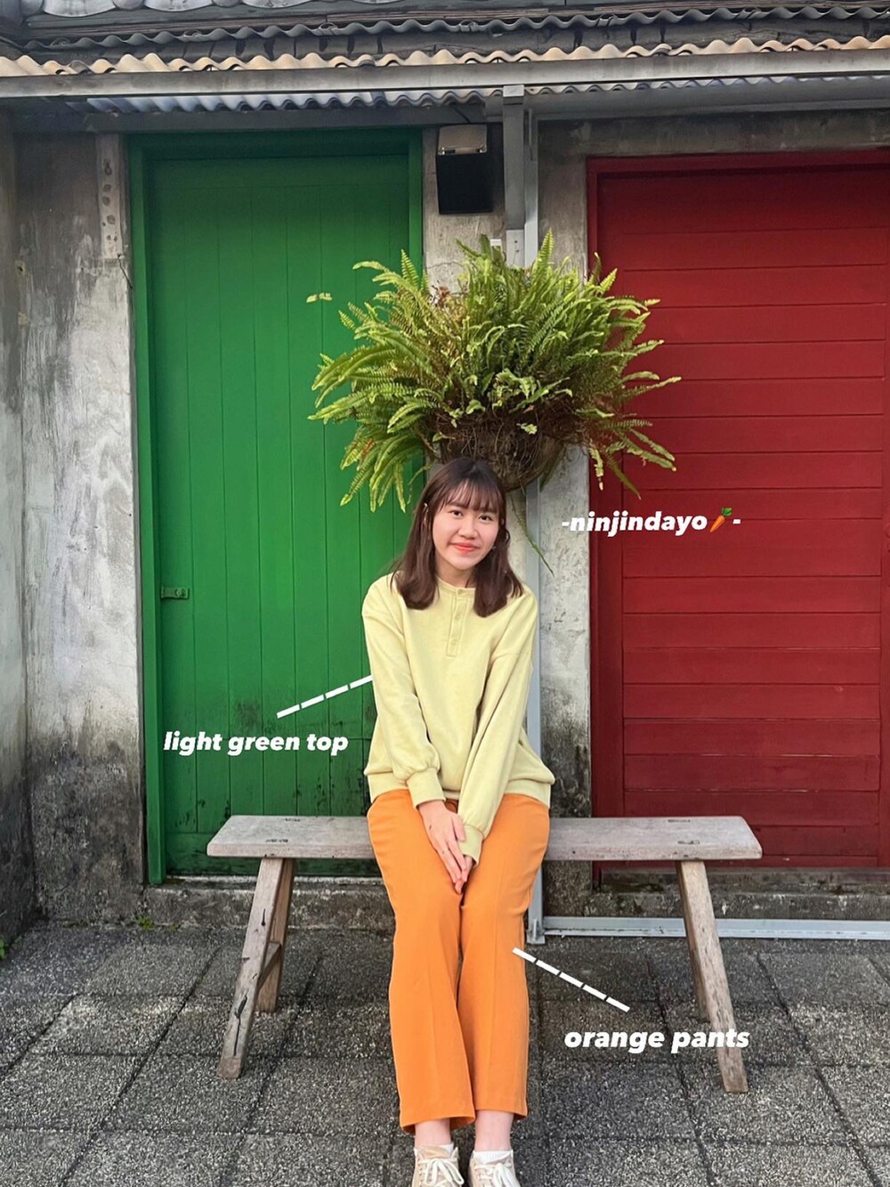 オレンジ系のスラックス、ベージュ系のシューズ、グリーン系のTシャツ/カットソーを着用したレディースの冬コーディネートの2枚目の写真