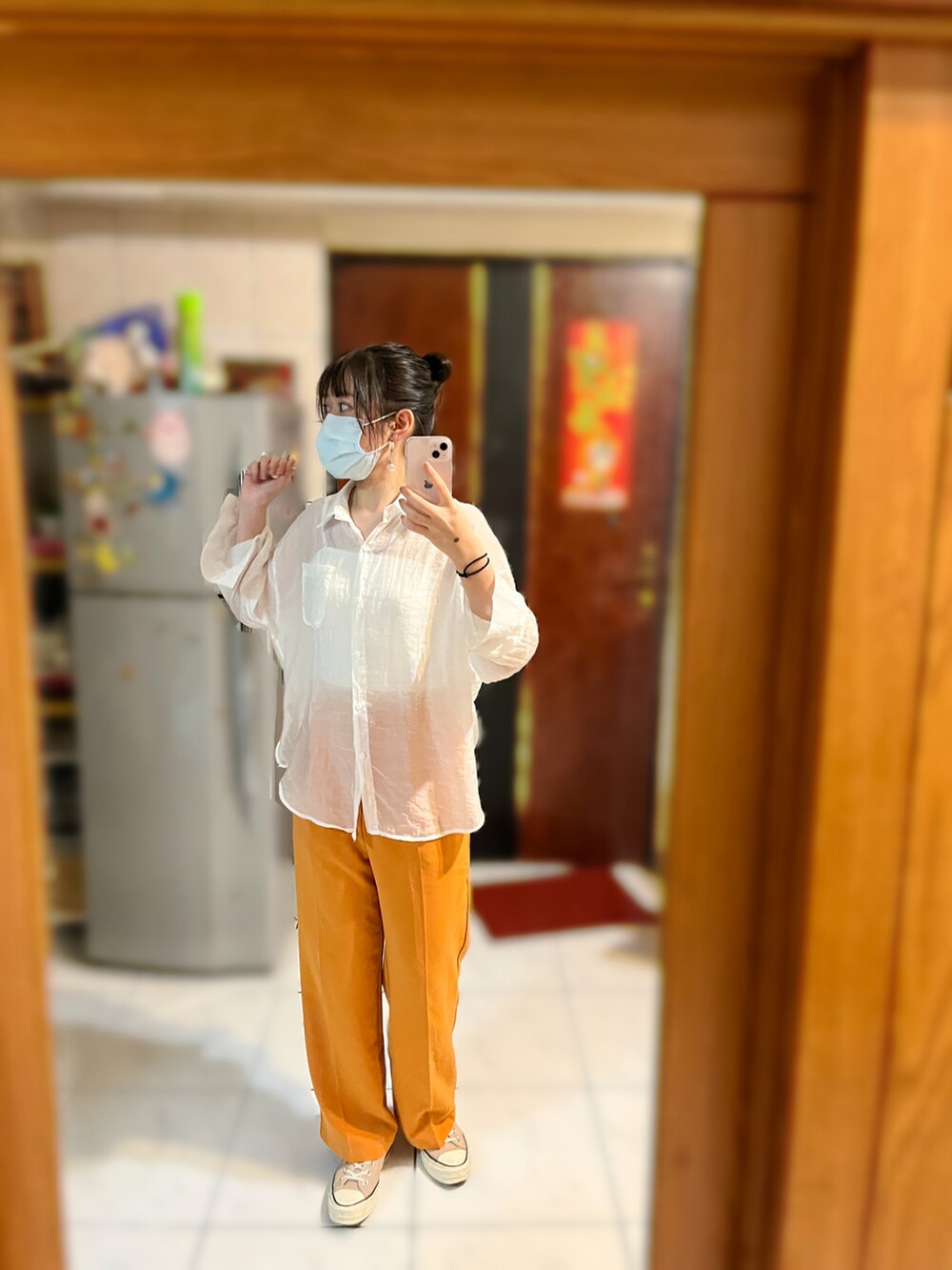 オレンジ系のスラックス、ホワイト系のシャツ/ブラウス、ホワイト系のチューブトップを着用したレディースの秋コーディネートの3枚目の写真