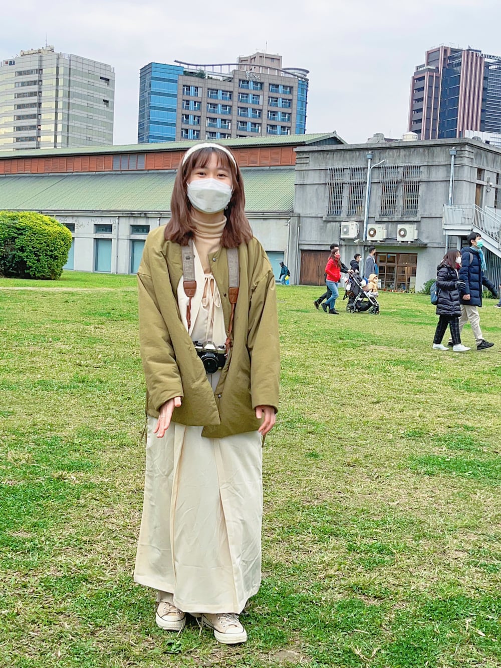 グリーン系のその他アウター、ホワイト系のジャンパースカートを着用したレディースの冬コーディネートの2枚目の写真