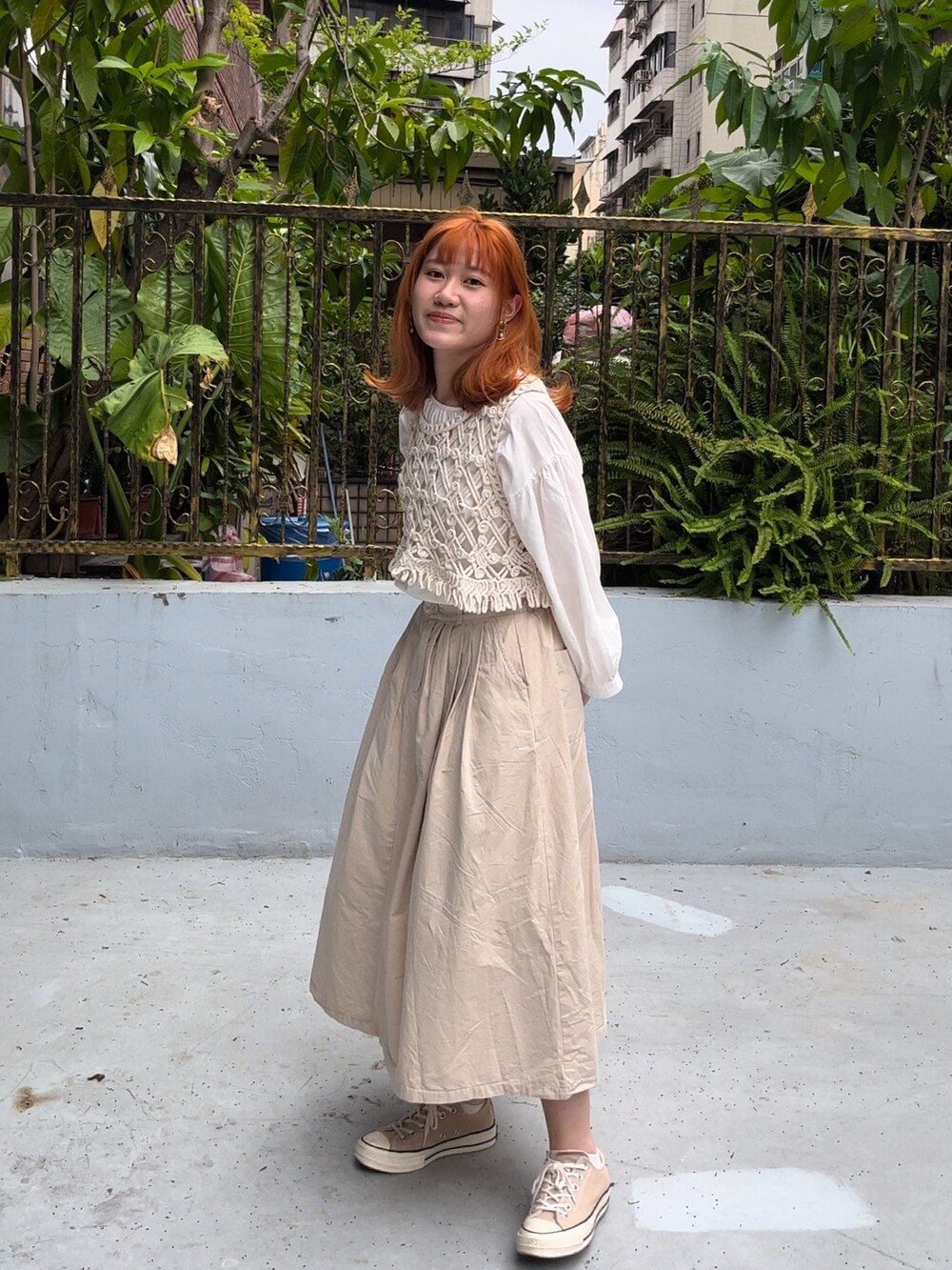 ベージュ系のスカート、ホワイト系のシャツ/ブラウス、ベージュ系のベストを着用したレディースの秋コーディネートの4枚目の写真