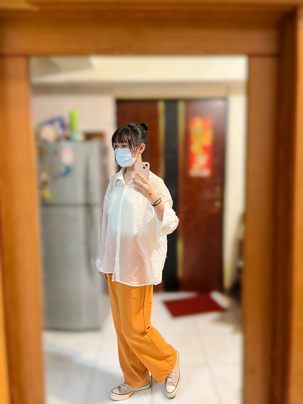 オレンジ系のスラックス、ホワイト系のシャツ/ブラウス、ホワイト系のチューブトップを着用したレディースの秋コーディネートの5枚目の写真