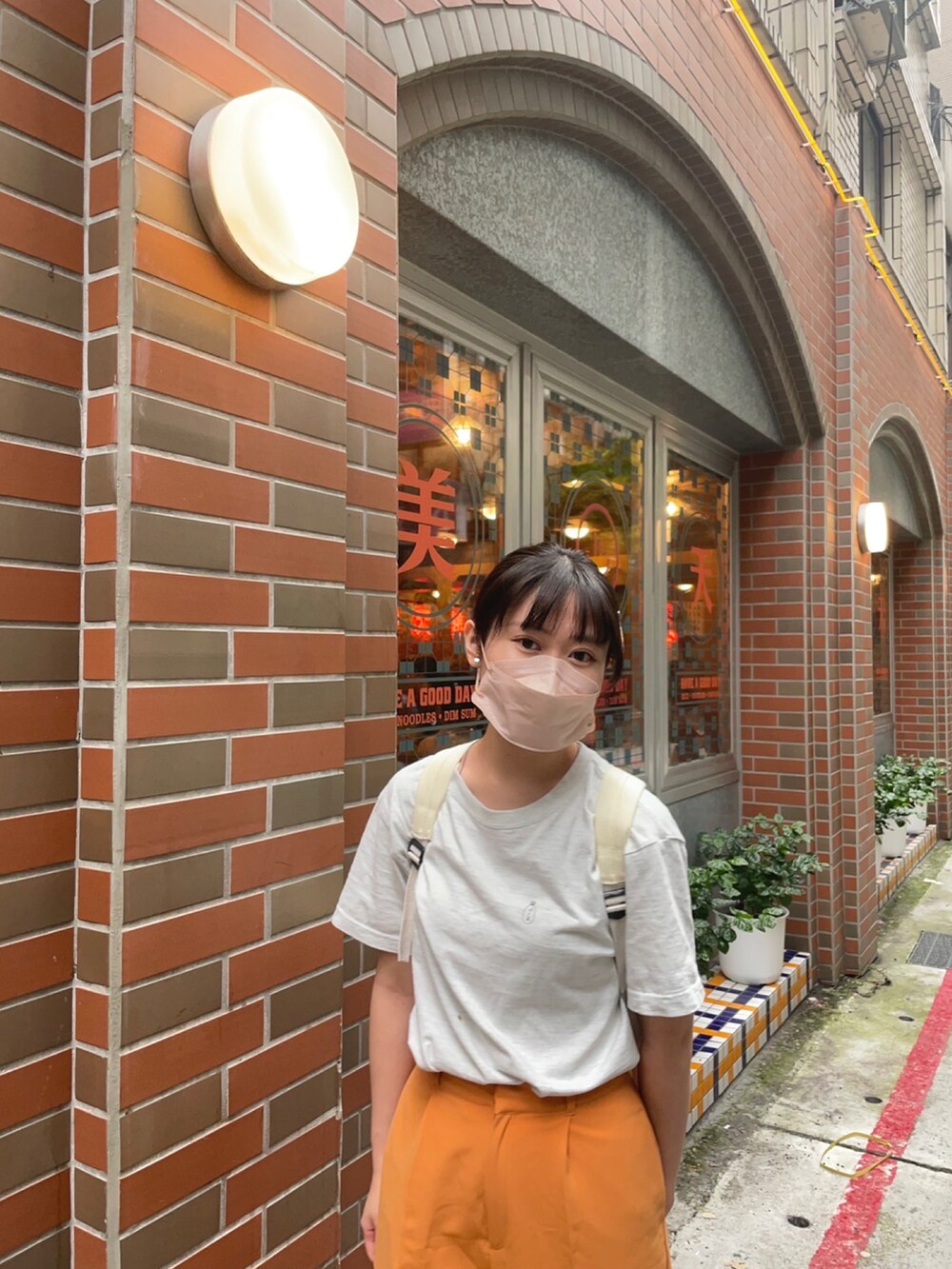 グレー系のTシャツ/カットソー、オレンジ系のチノパンツ、ブラック系のシャツ/ブラウスを着用したレディースの秋コーディネートの4枚目の写真